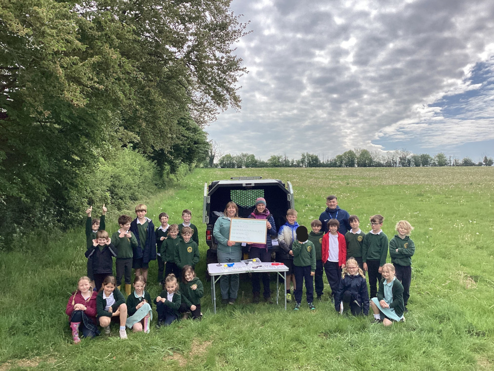 Group of school children in a field next to Sapperton Wilder buggy and a big whiteboard
